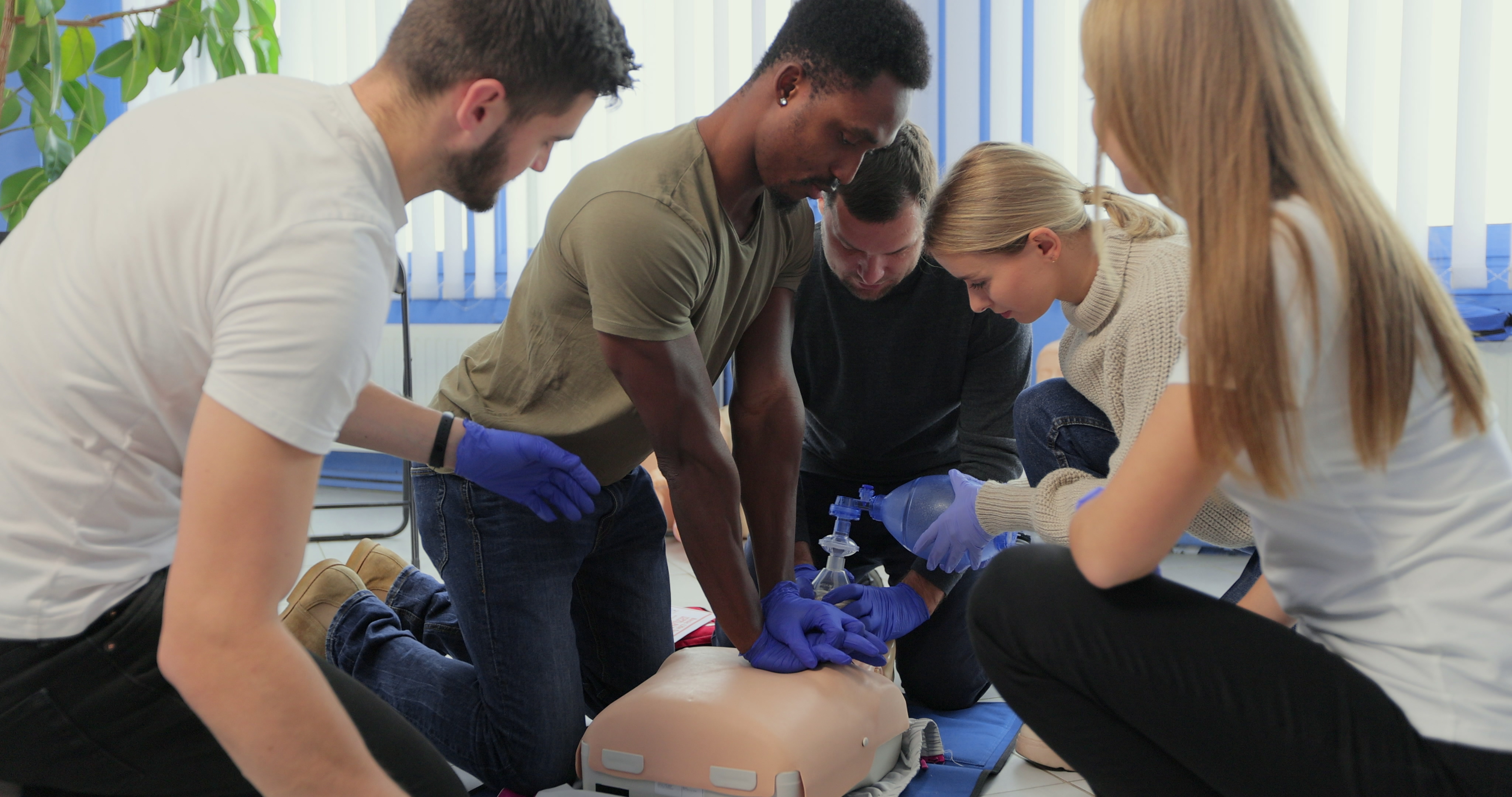 Closeup of students practicing CPR chest compression on dummy.